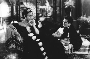 A still shot from the 1937 Chinese film "Crossroads," featuring an actress on the left and an actor on the right dressed in black-tie attire. 