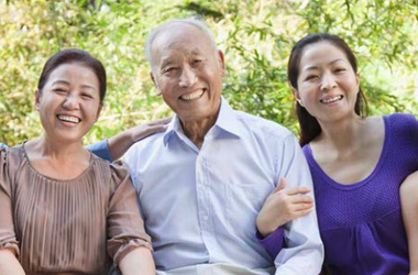 Five Chinese Americans sitting together and smiling at the camera
